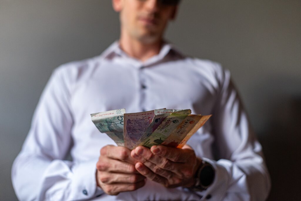 a man counting money and comparing the lump sum vs monthly alimony payments